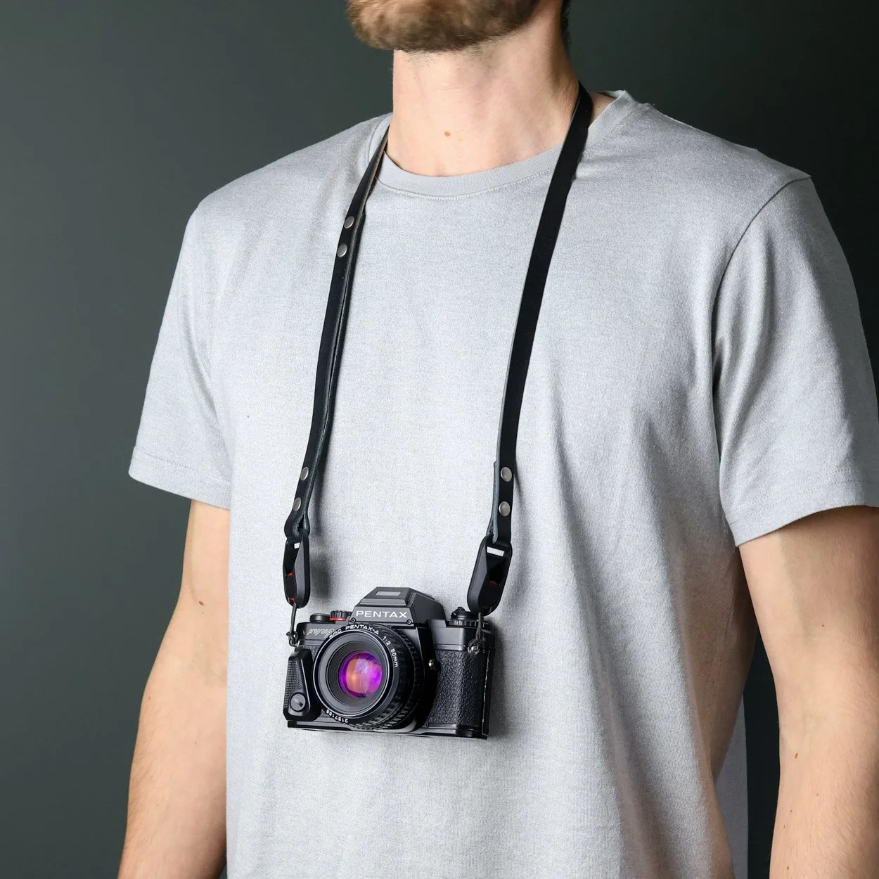 Black Quick release camera strap being worn on the neck