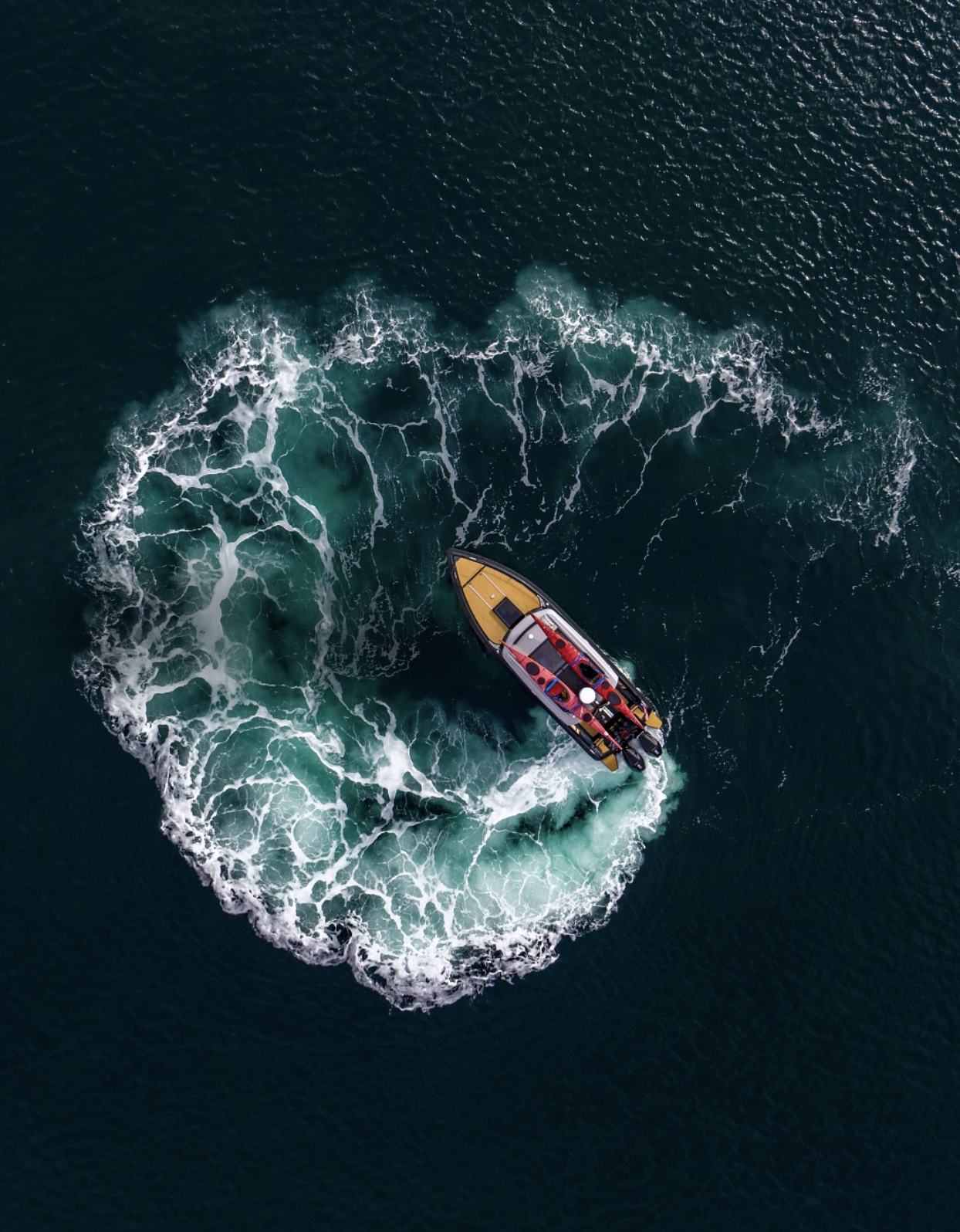 A boat moving through the water, creating waves and foam in its wake.