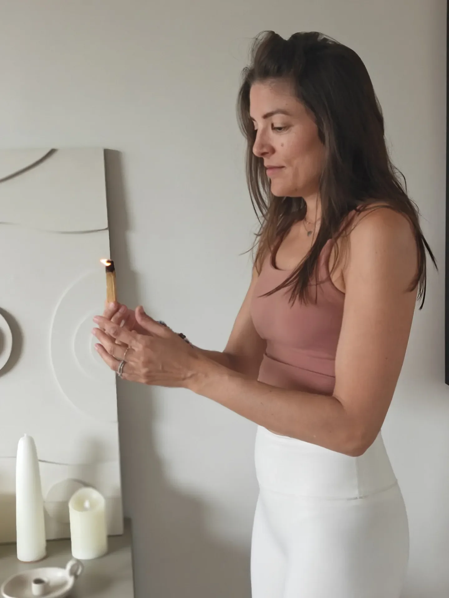 Žena stvara ritual svjesnog življenja paleći svijeću kao simbol prisutnosti, unutarnjeg mira i osobnog razvoja.