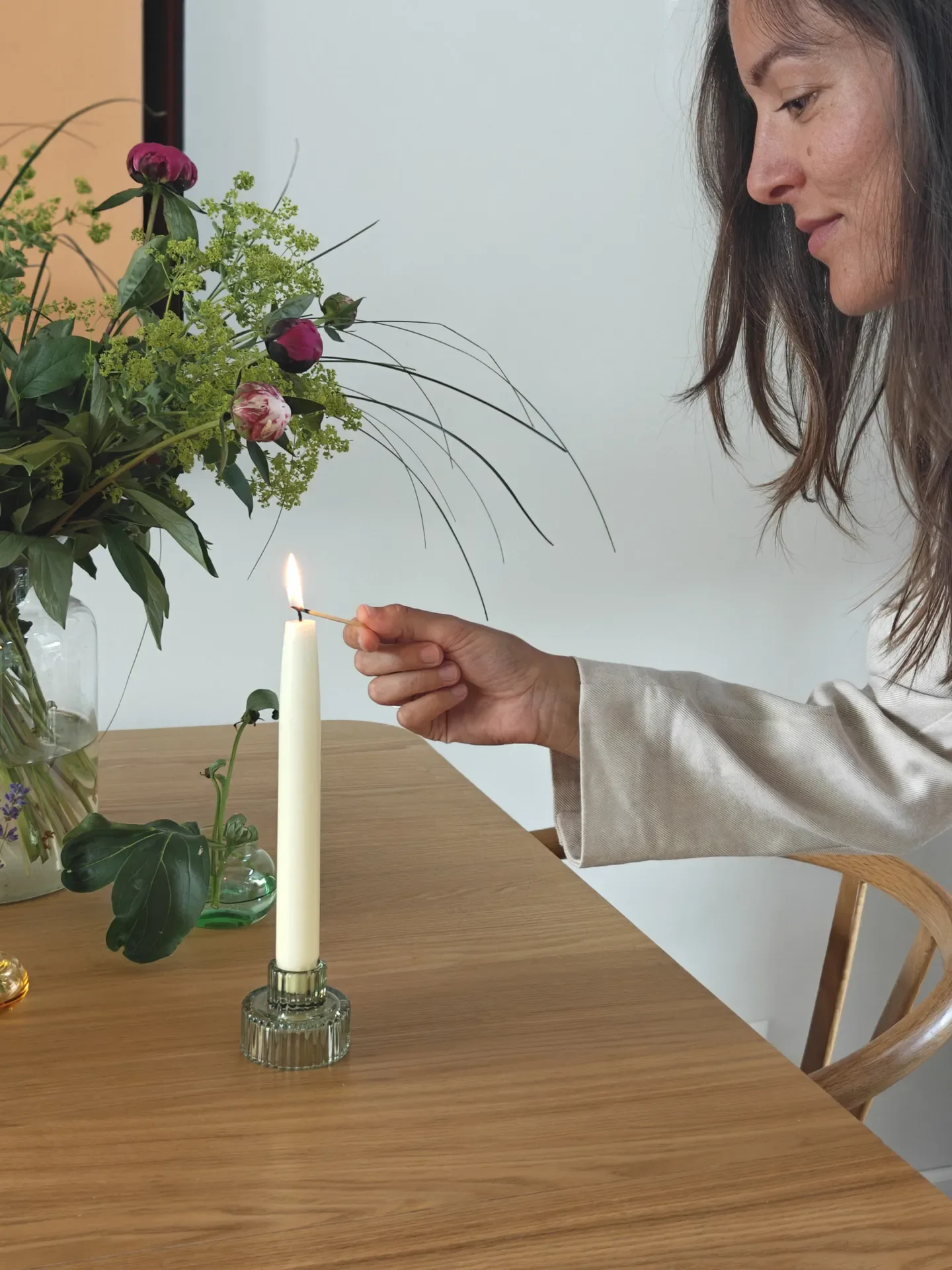 Žena pali svijeću prije meditacije i prakse svjesnog življenja u inspirativnom i opuštajućem prostoru.