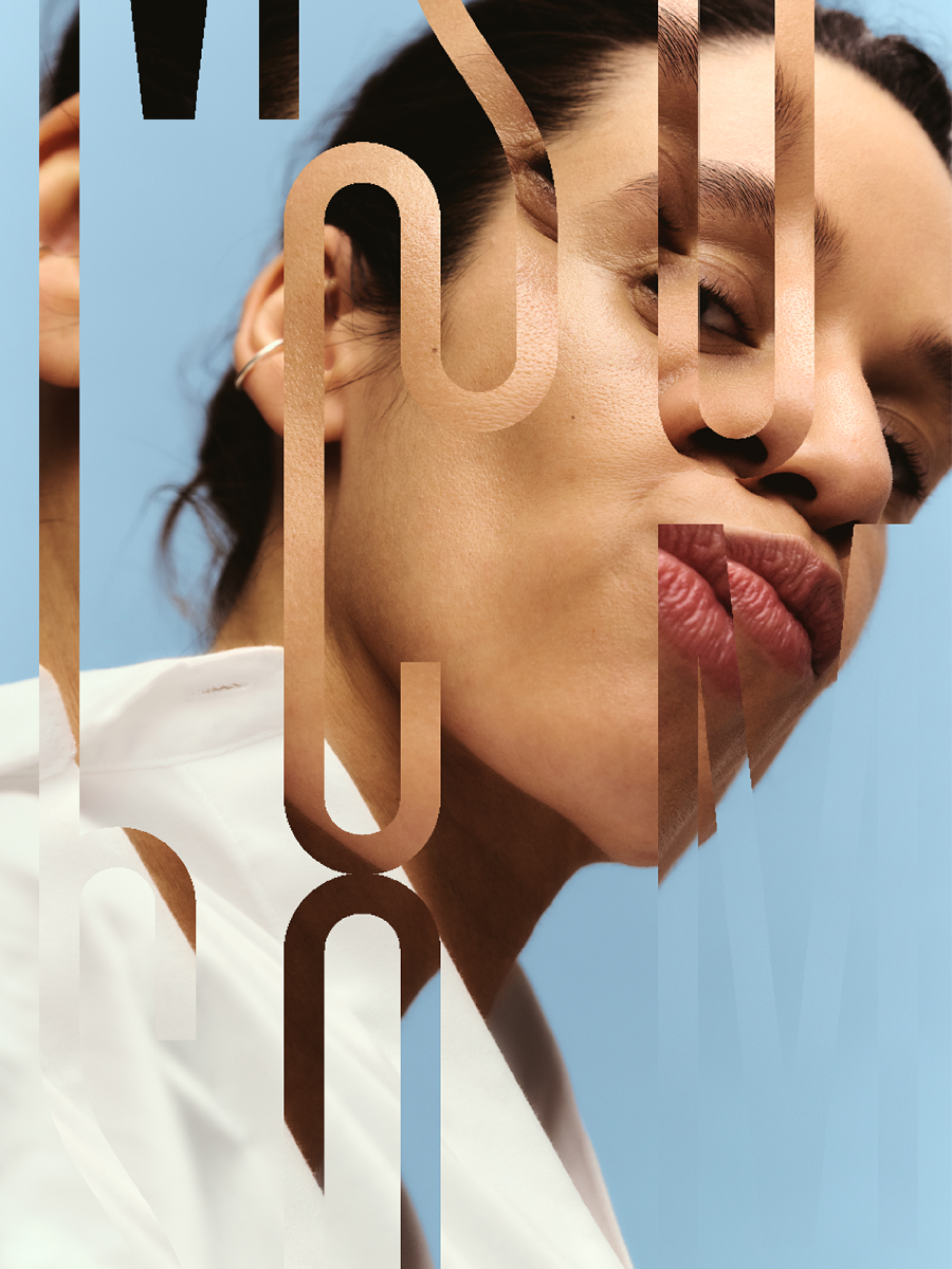 Close-up of a woman with dark hair and a white top, with stylized overlapping metallic text placed over her face against a light blue background.