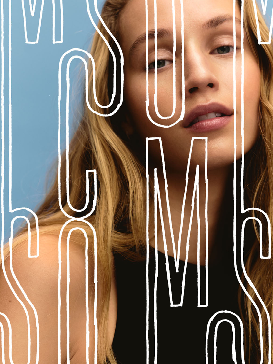 Close-up of a young woman with long blonde hair and light skin, partially obscured by white, hand-drawn text that reads 'YOUTH' on a blue background.