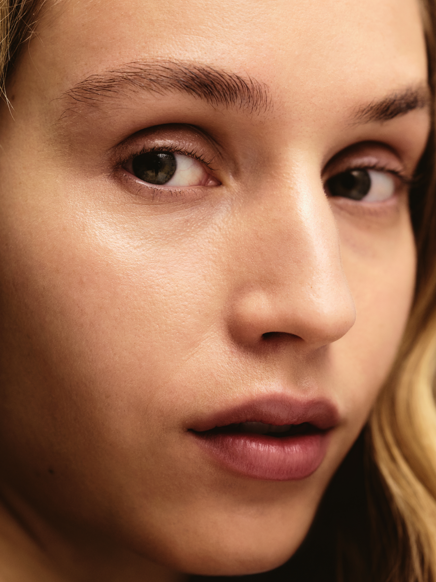 Close-up of a woman's face focusing on her left eye, eyebrow, and lips, with smooth skin and natural makeup.