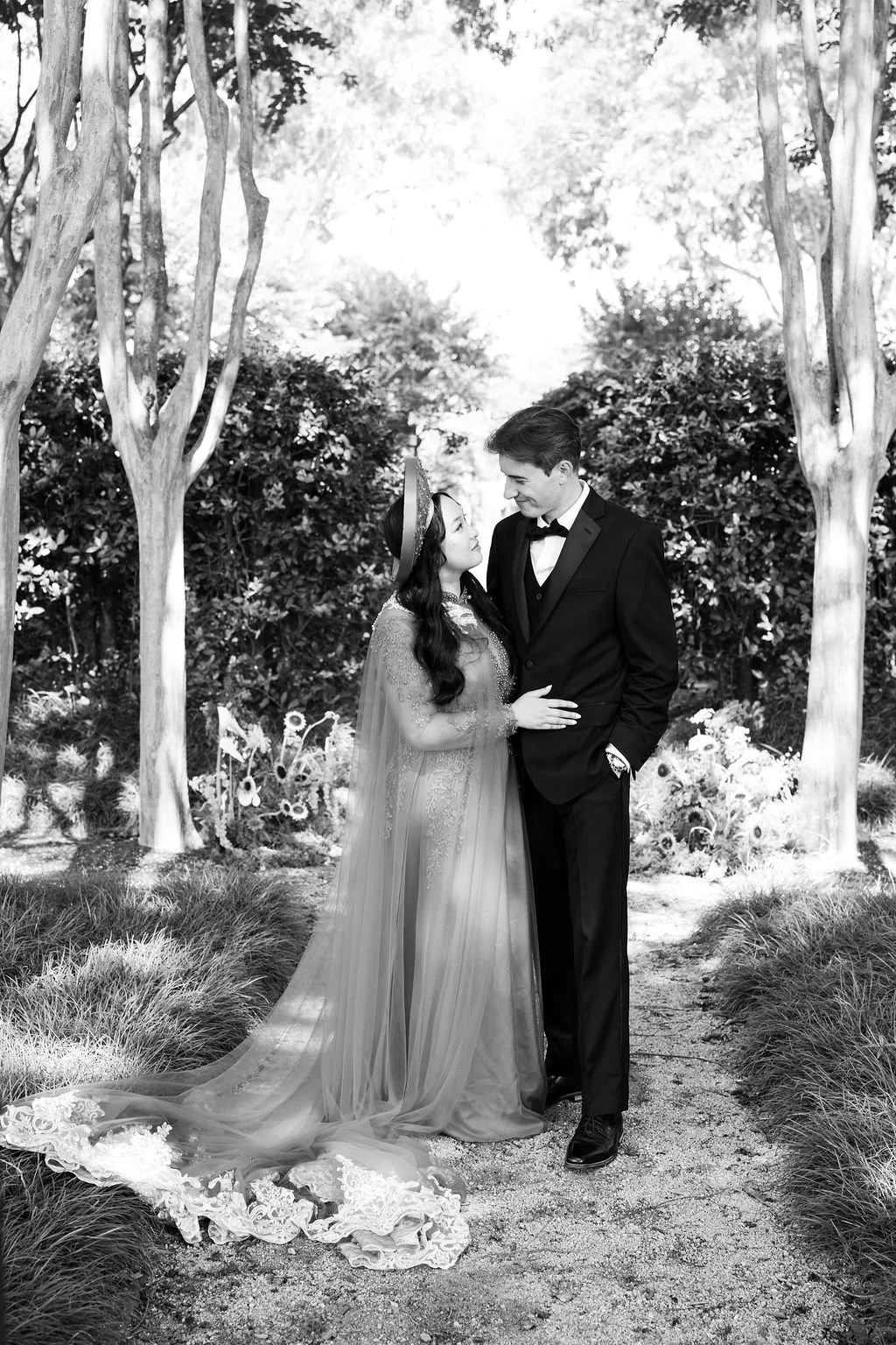 Decorated dining table with red and white flowers, candles, and glasses, set in front of large windows with natural light.