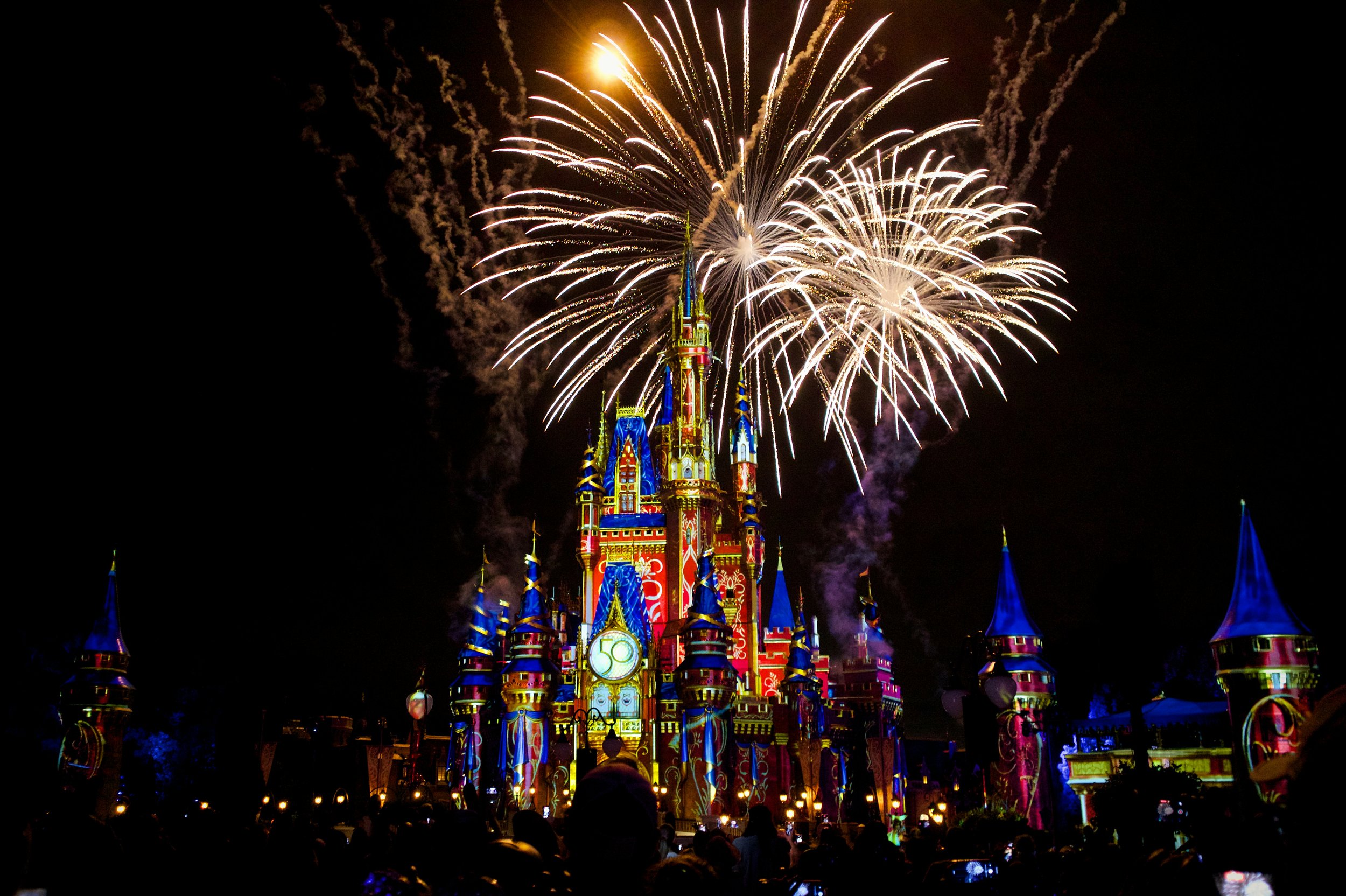 Fireworks explode over Sleeping Beauty Castle decorated for Disney 50th anniversary at Disneyland.