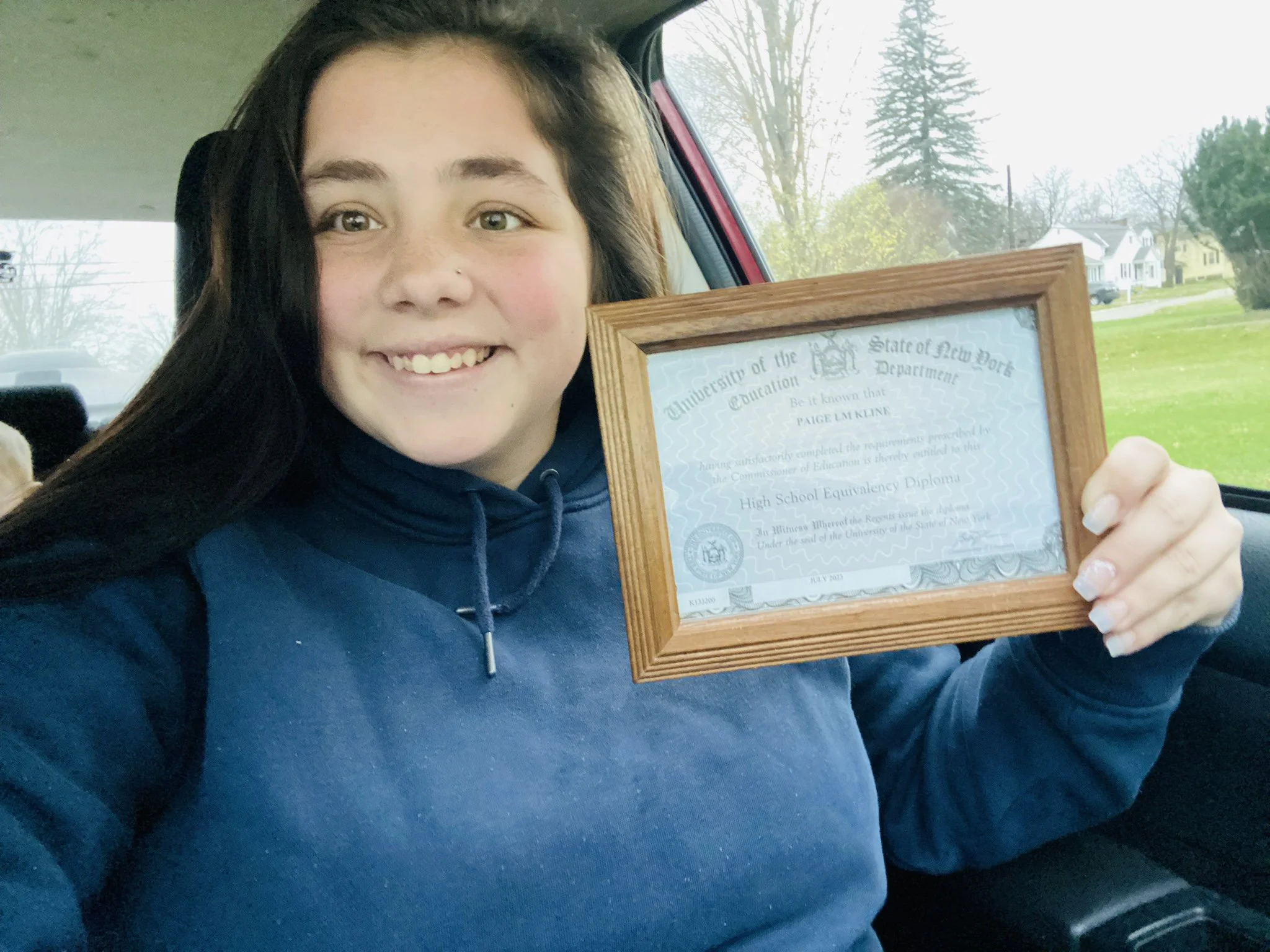 Woman holding GED certificate