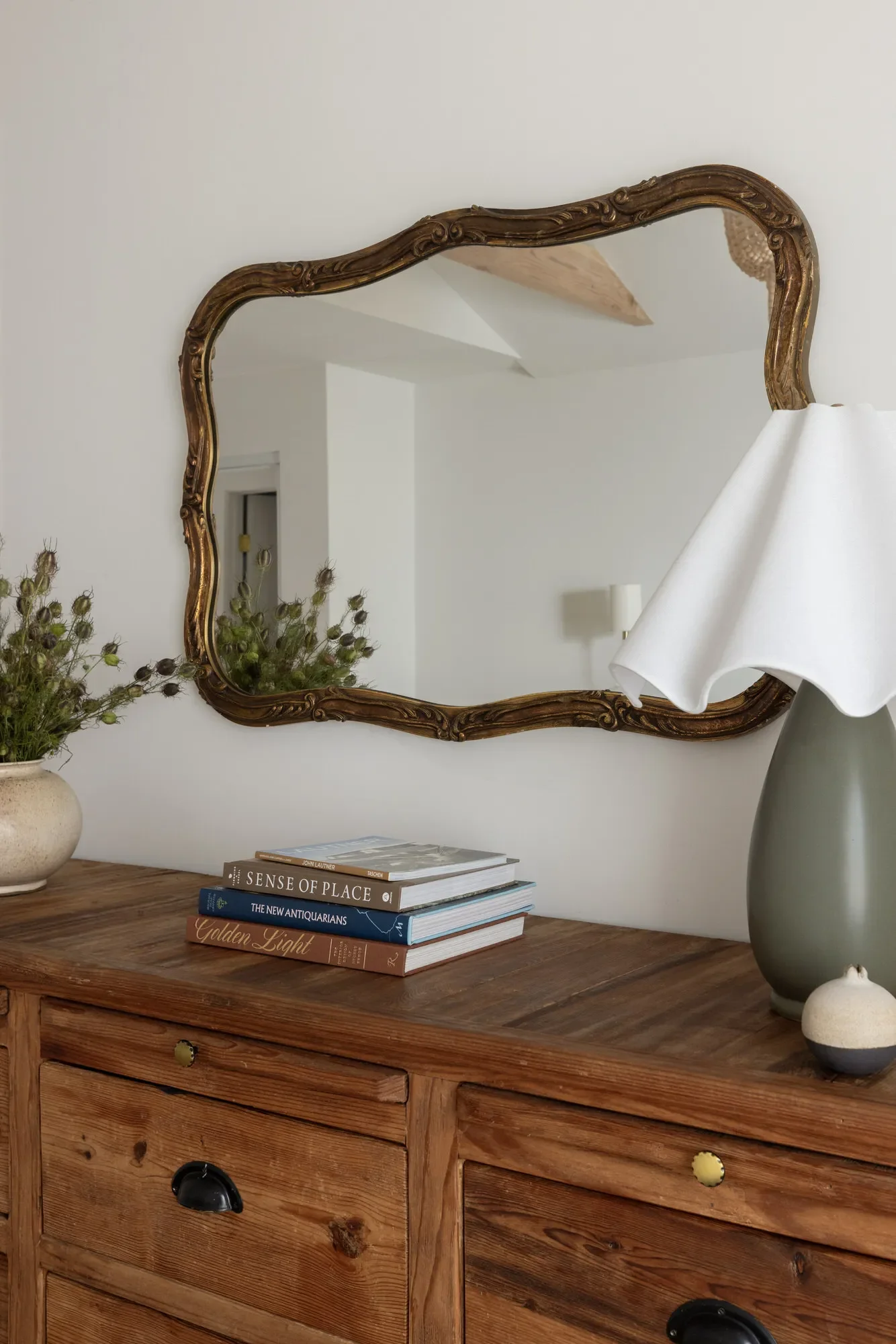 Interior styling detail from a Studio VAE residential project in the Bay Area — antique gilt mirror, fluted lamp, and curated books.