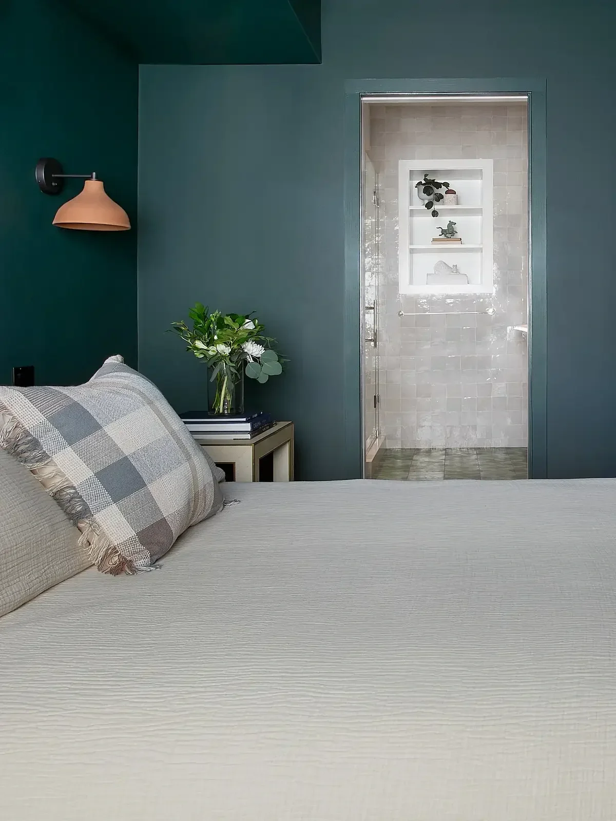 Bedroom painted deep forest green with view through to ensuite beyond, in Claremont Berkeley home designed by Studio VAE, Bay Area interior designer.