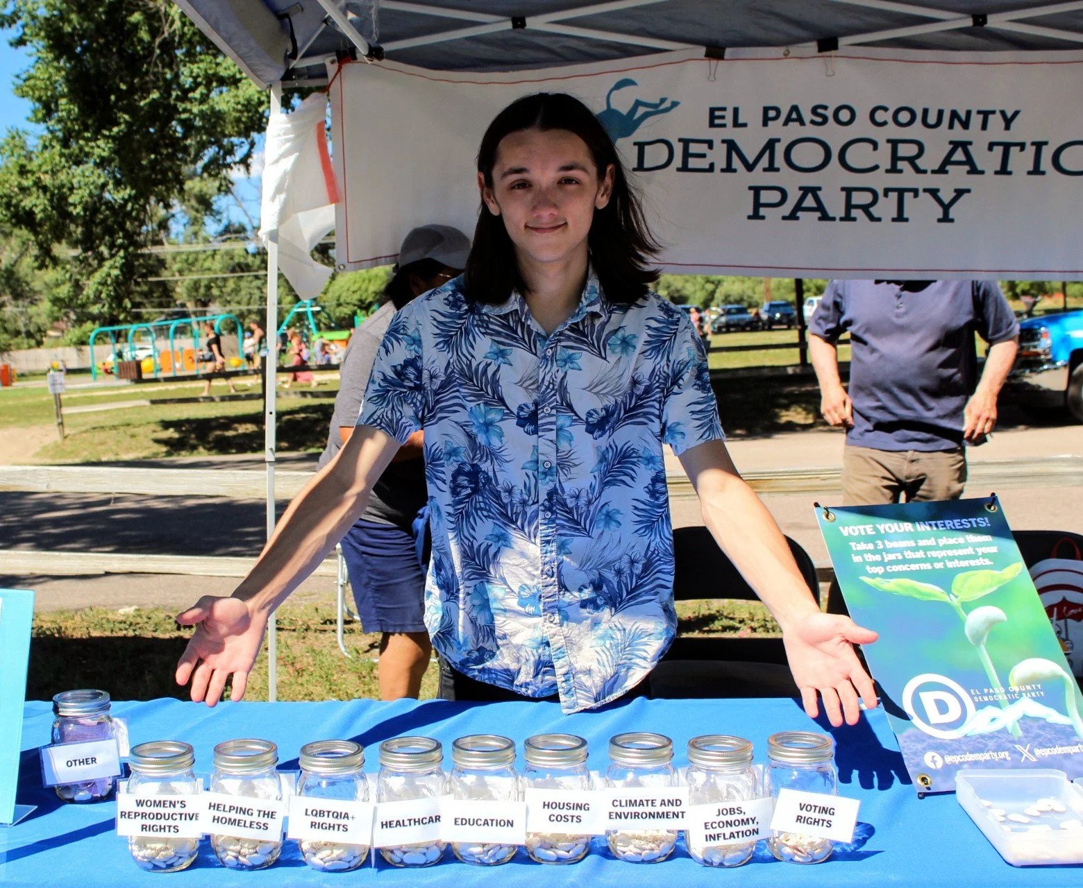Person at El Paso County Democratic Party booth with issue jars