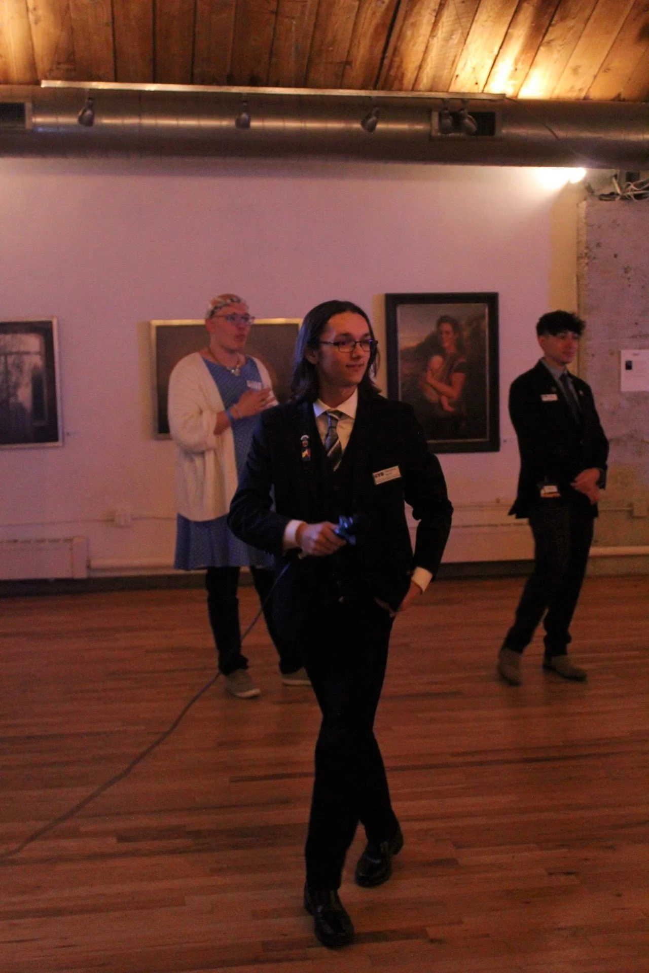 People in a room with art and wooden ceiling