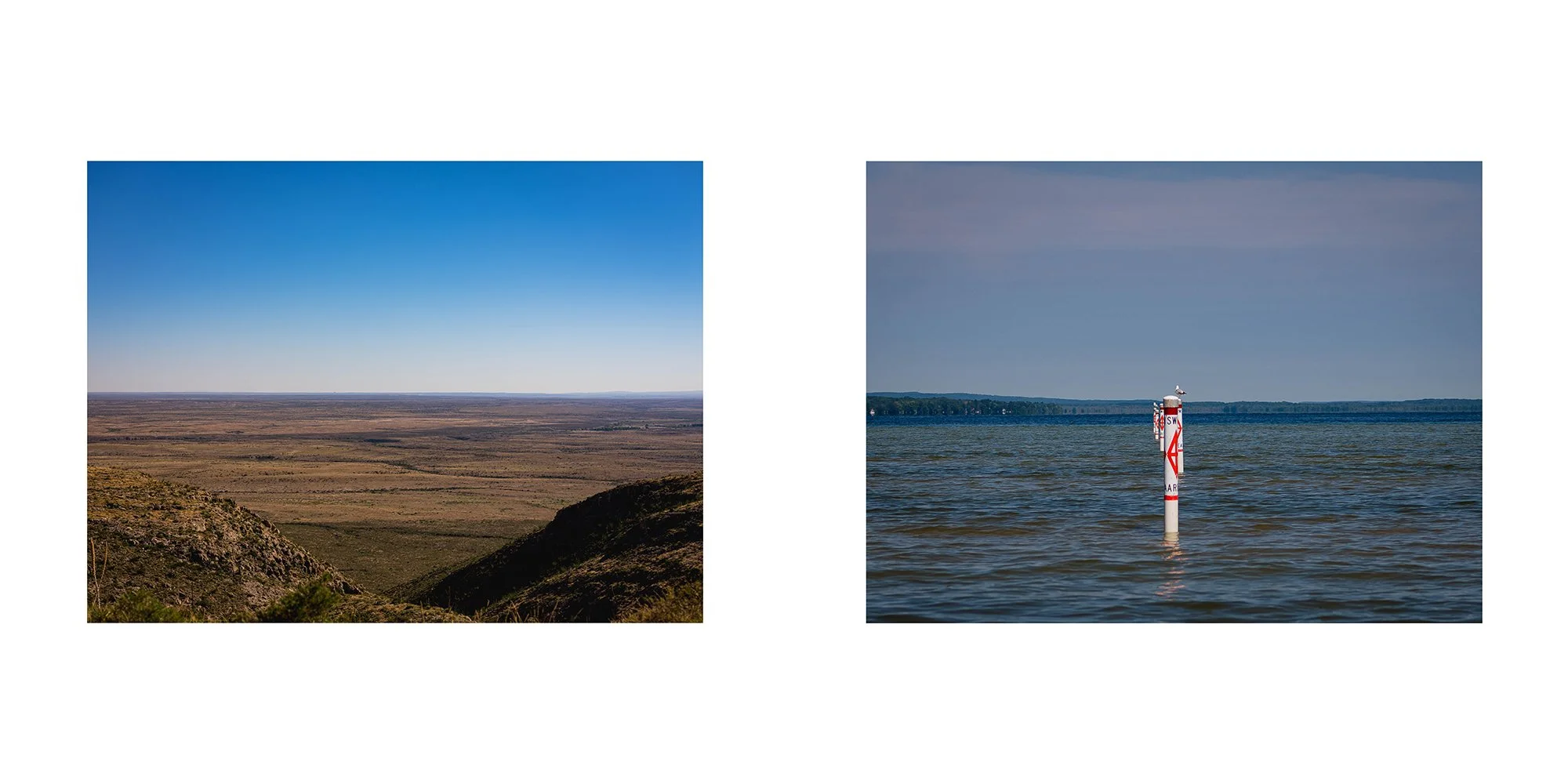 Landscape with open plains and a blue sky on the left, and a body of water with a navigational marker and distant shoreline on the right.