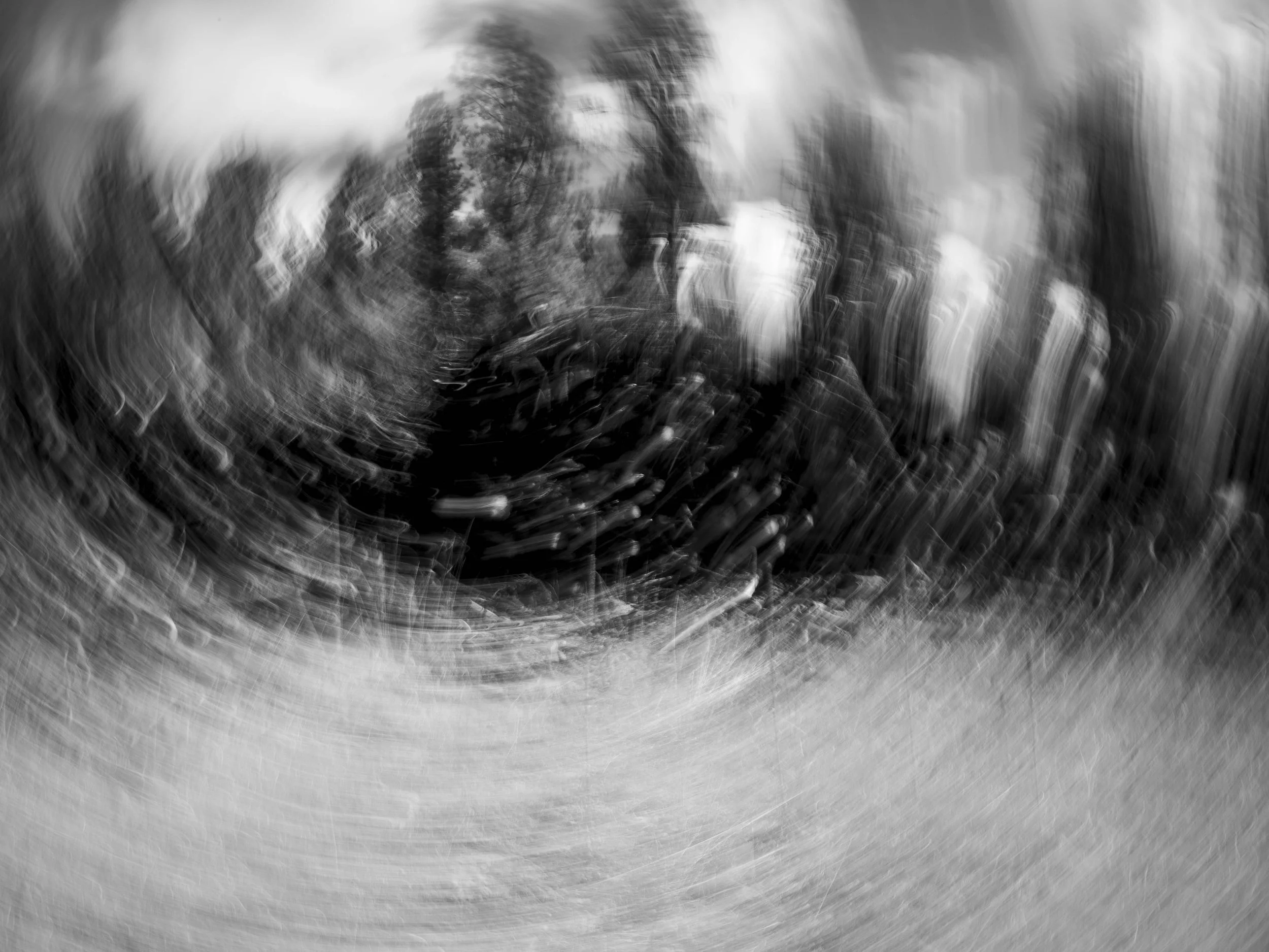 A black and white abstract photo with a distorted face and swirling patterns.