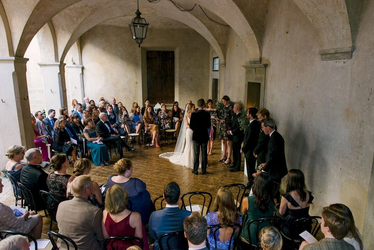 Wedding ceremony at Castello di Montegufoni with the couple standing together inside the intimate stone courtyard.