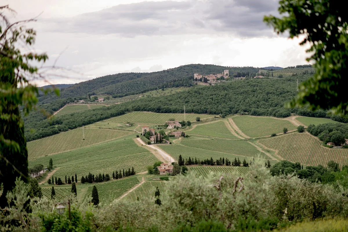 View across Chianti vineyards and rolling Tuscan hills from Castello di Meleto wedding venue in Tuscany.