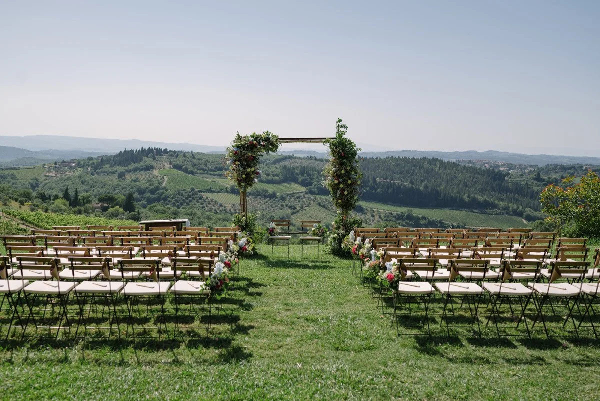 Wedding ceremony arch with vineyard views photographed before guests arrive at Le Filigare wedding venue in Tuscany.