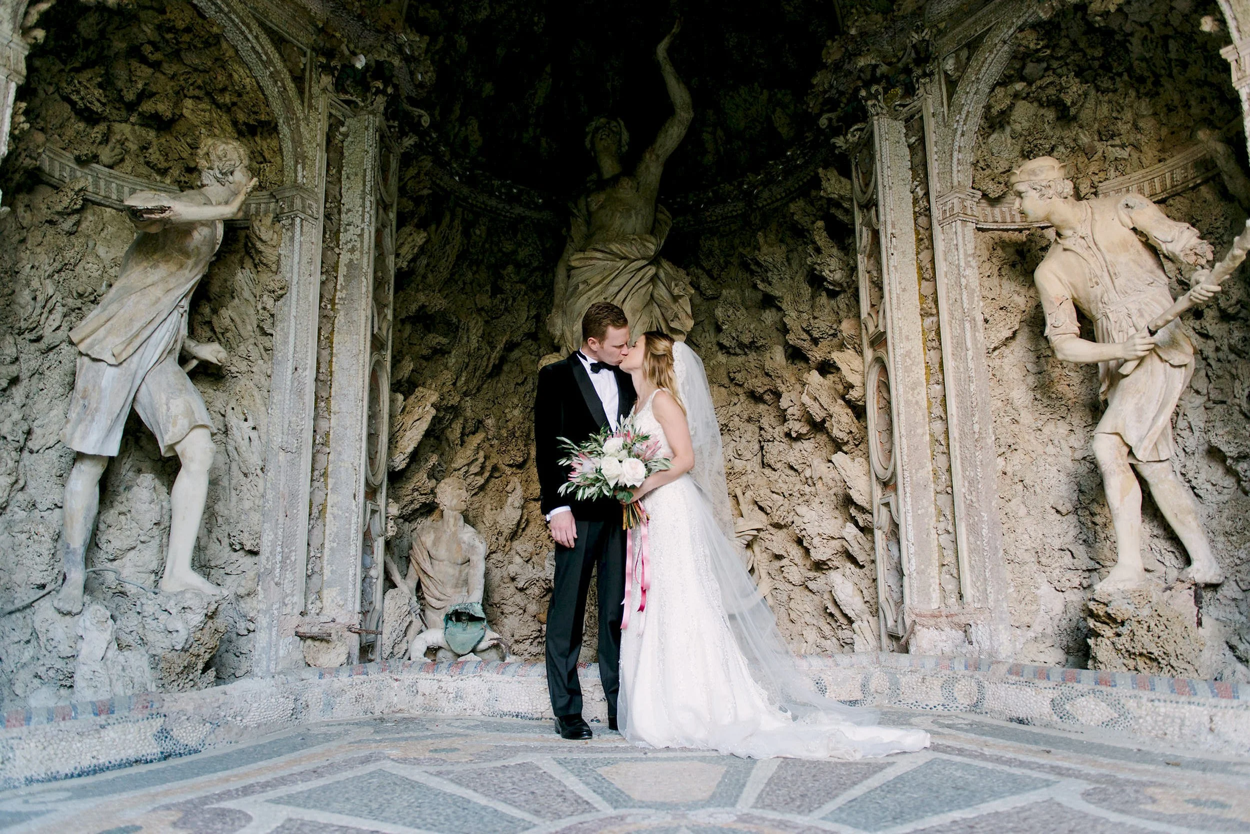 Wedding couple kissing inside the grotto at Castello di Montegufoni, a unique portrait location on the property.