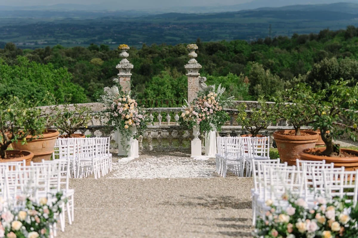 Wedding ceremony setup at Castello di Celsa with floral arrangements and open views across the Tuscan countryside.