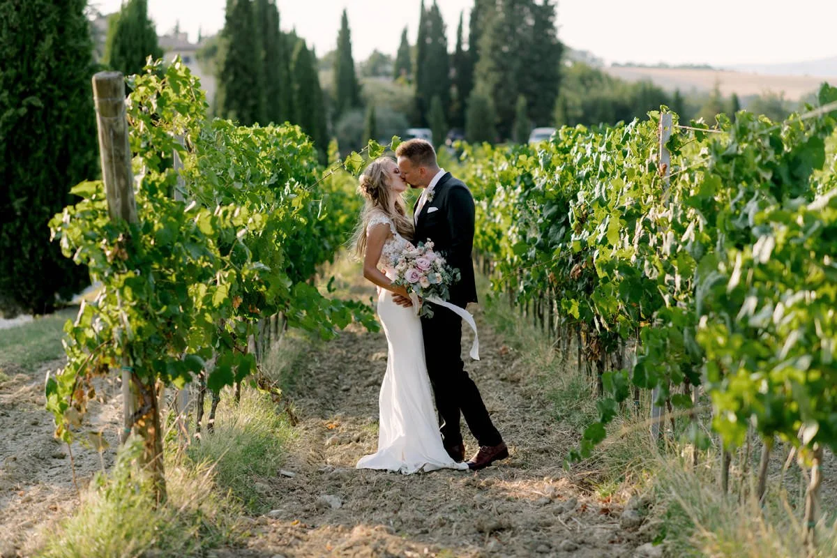 Couple kissing in the middle of the vineyards at Terre di Nano wedding venue in Val d’Orcia