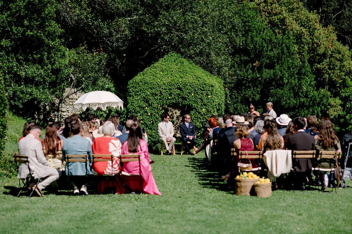 Wedding ceremony at Villa di Ulignano using the secondary garden ceremony spot beside the pool, surrounded by greenery.