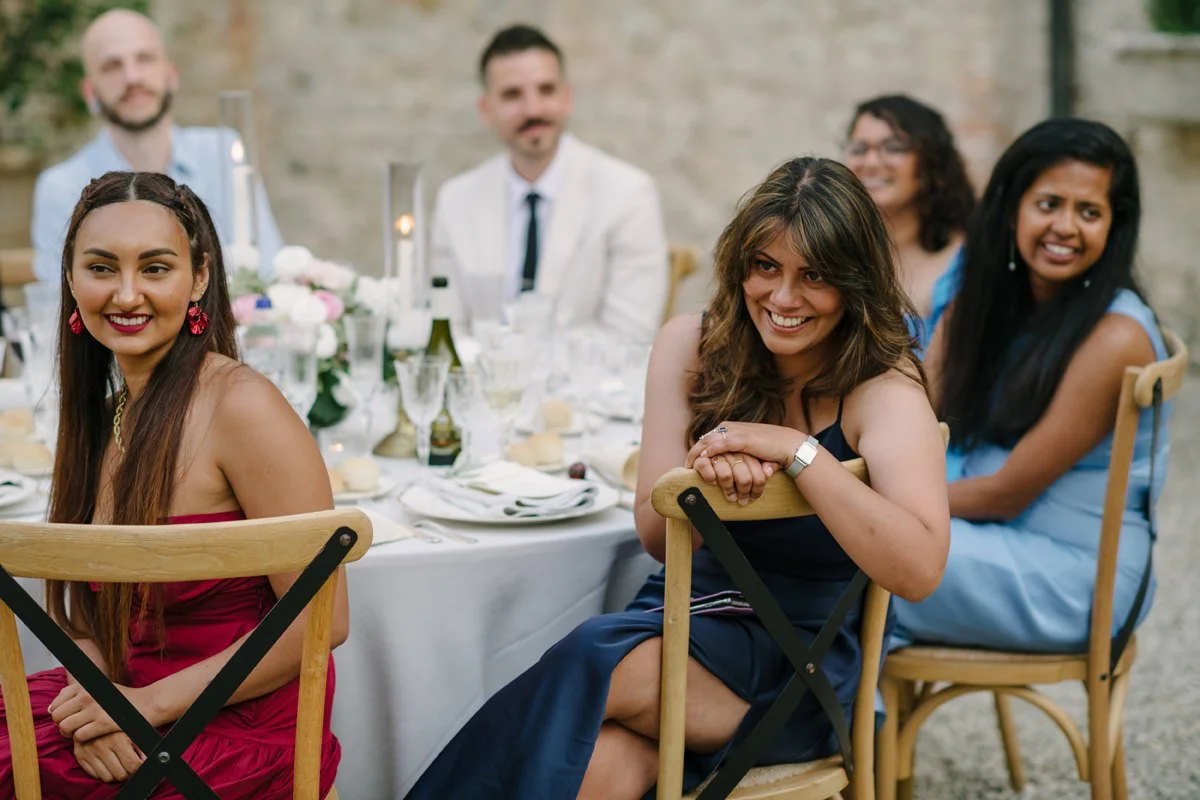 Wedding guests laughing and listening to speeches during the reception at Tenuta di Monaciano.