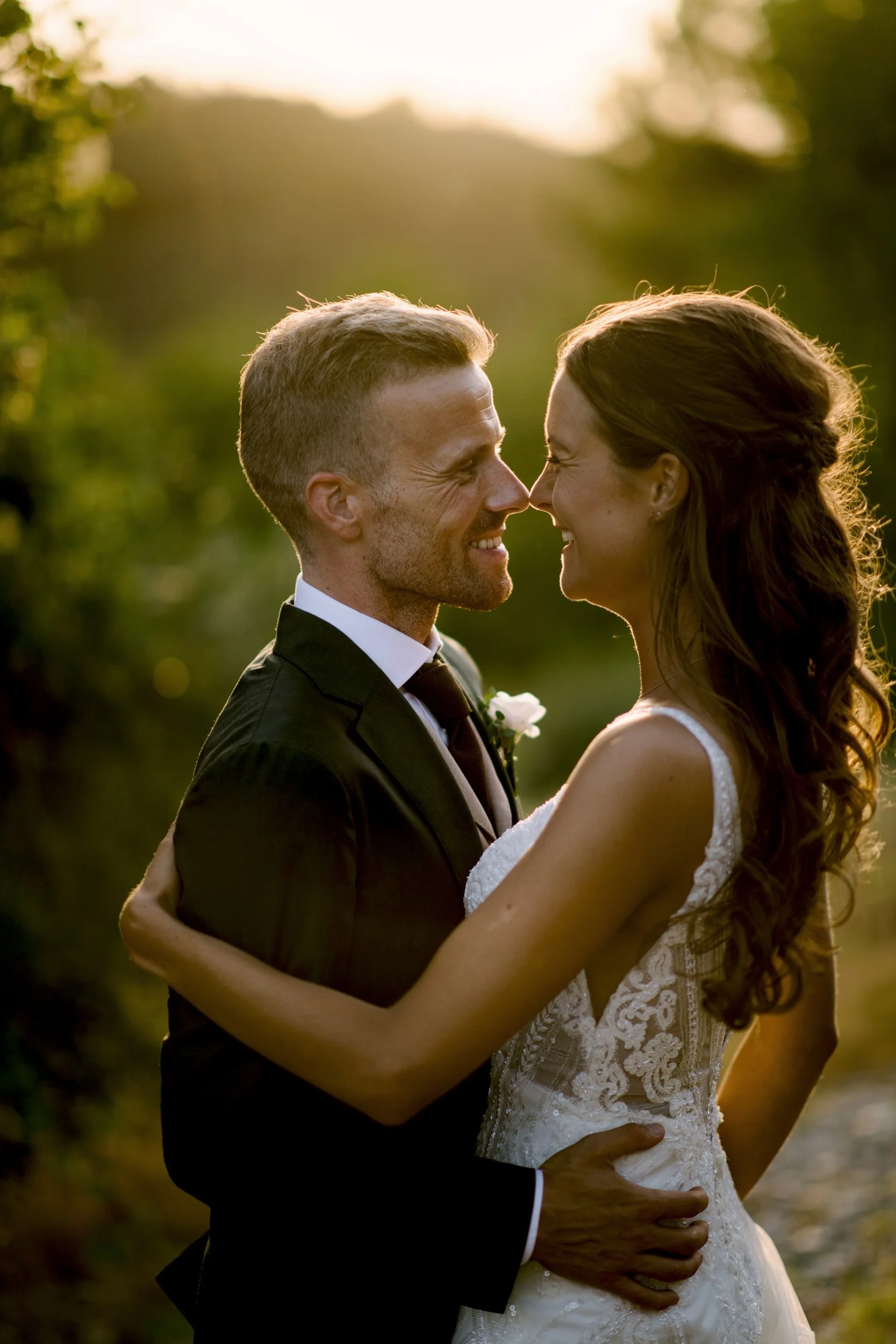 Couple forehead to forehead in low evening light among the olive trees at Borgo della Meliana, Gambassi Terme