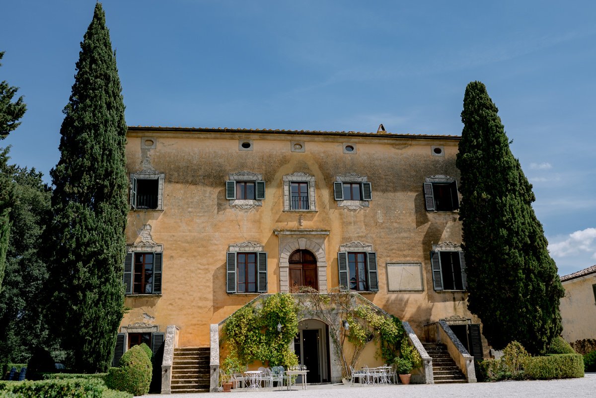 Front exterior of Villa di Ulignano on a summer day, showing the venue without wedding setup to highlight the architecture and surroundings.