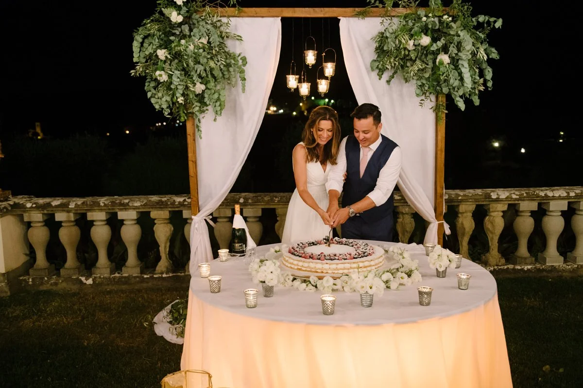 Wedding couple cutting their cake during the reception at Villa Artimino in Tuscany.
