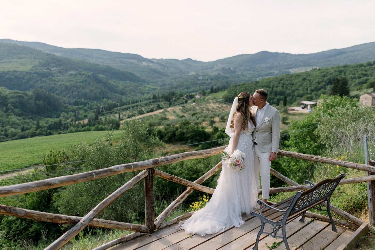Bride and groom on a small terrace at Castello del Trebbio overlooking the Chianti vineyards.