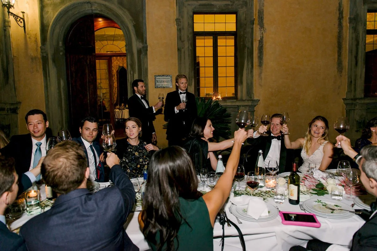 Bride and groom celebrating with guests during the wedding dinner at Castello di Montegufoni.
