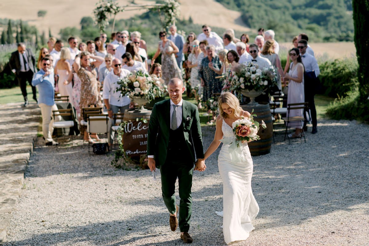 Just married couple walking away after their ceremony at Terre di Nano in Val d’Orcia.