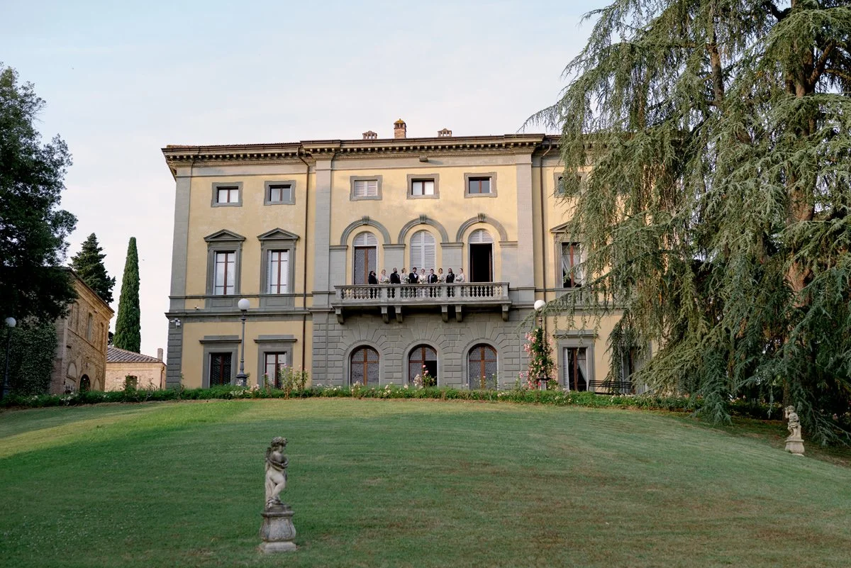 Bride and groom with bridesmaids and groomsmen on the villa terrace at Tenuta di Monaciano wedding venue.