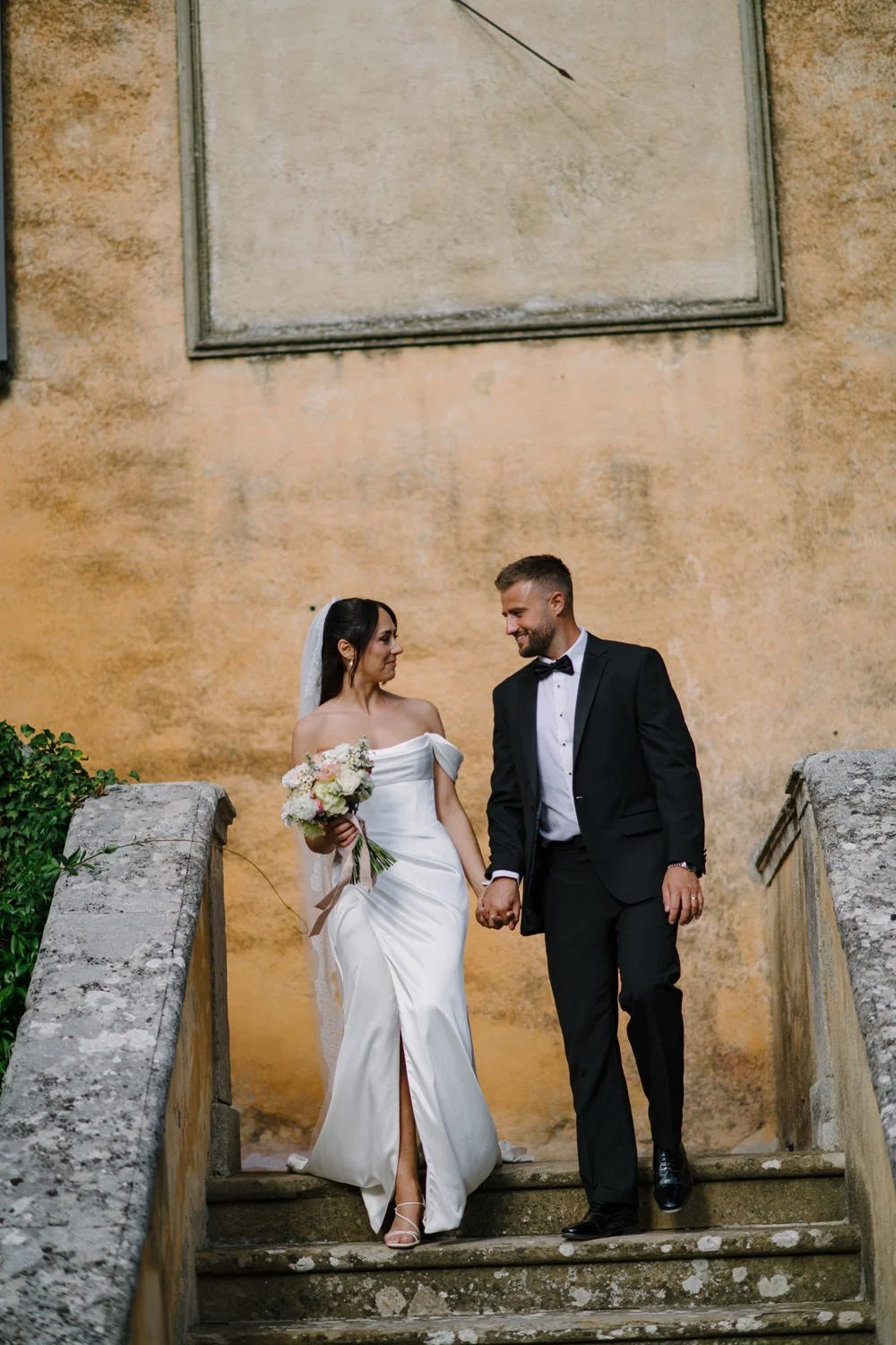 Bride and groom walking down the front stairs of Villa di Ulignano during golden hour, by FunkyBird