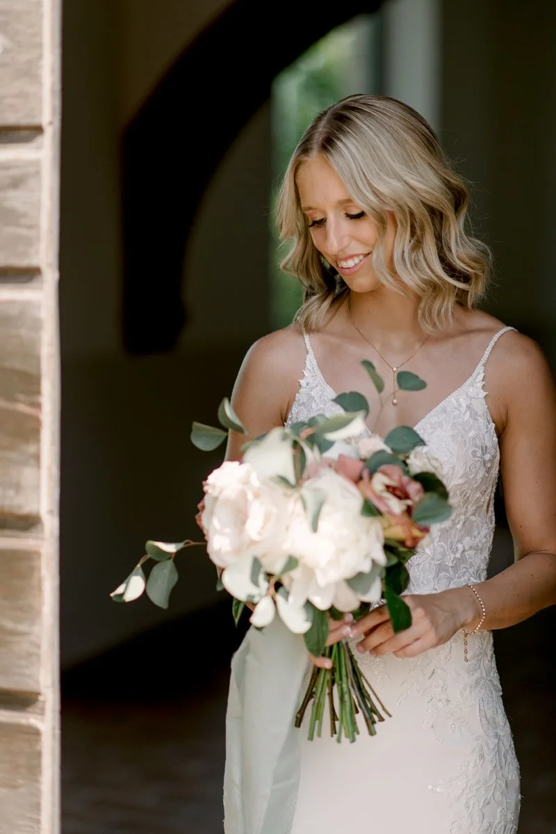 Bride holding a floral bouquet designed by FunkyBird Weddings at Terre di Nano wedding venue.