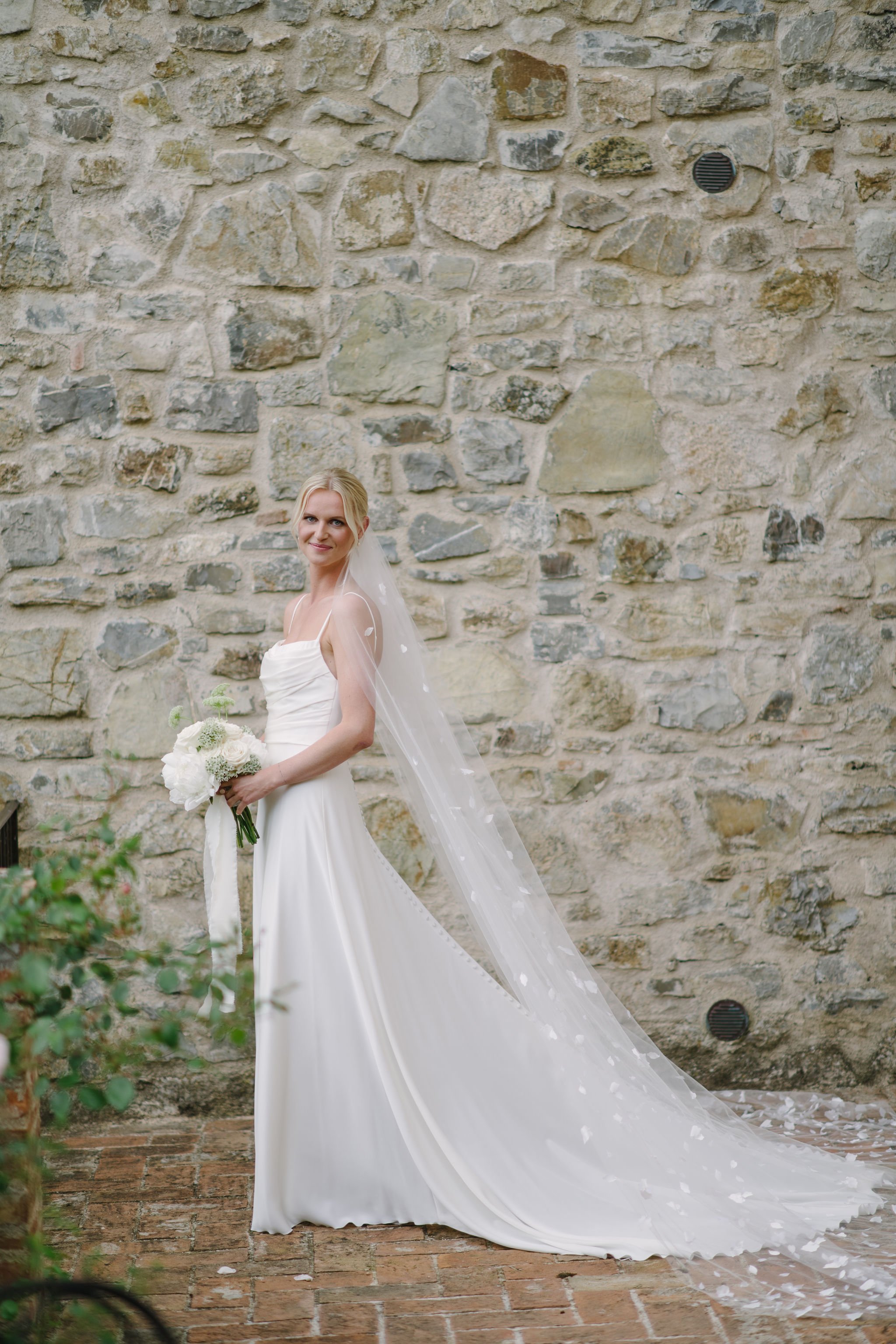 Tuscany wedding photographer taking photo of the bride in beautiful dress