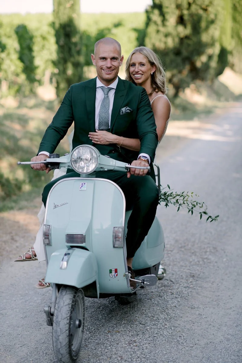 Wedding couple sitting on a Vespa and smiling at Terre di Nano in Val d’Orcia.