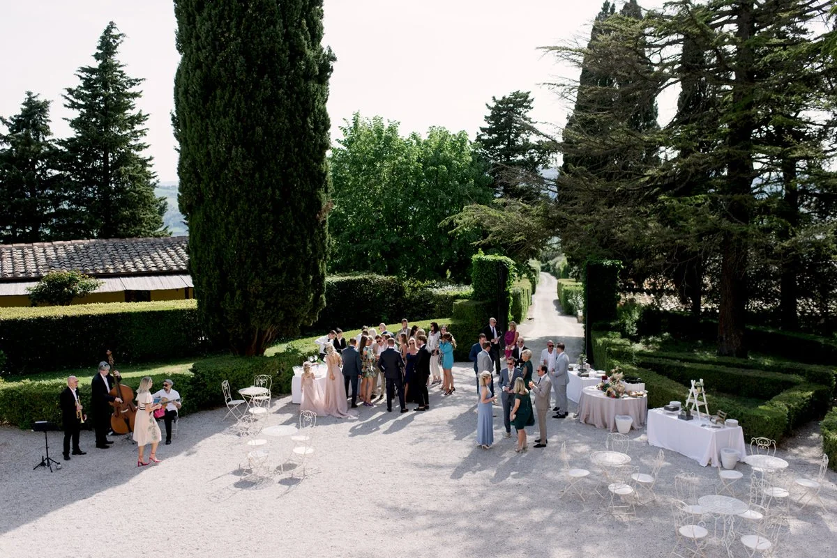 Wedding aperitivo in front of Villa di Ulignano, with guests mingling in the main outdoor space before dinner.