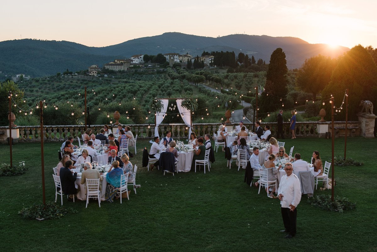 Wedding dinner at sunset at Villa Artimino with views over olive groves and the Tuscan countryside.