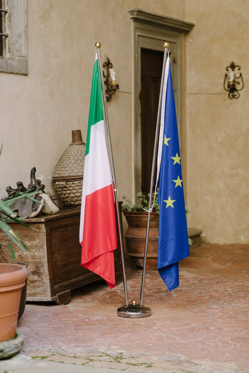Italian and European Union flags displayed during a civil wedding ceremony at Castello del Trebbio in Tuscany.