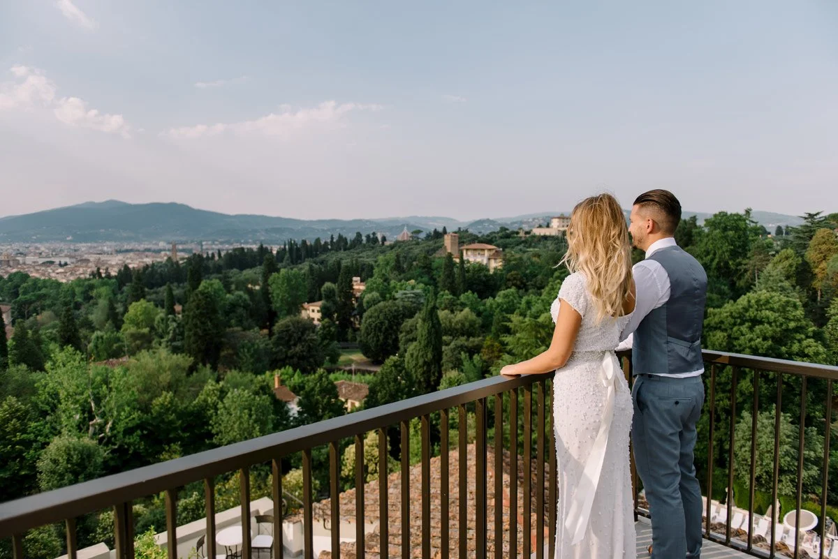 Couple standing on the terrace at Villa Cora, looking out toward Florence and the surrounding Tuscan hills.
