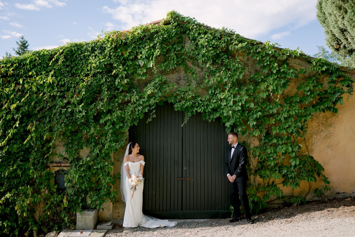 Bride and groom in front of a small house at the Villa di Ulignano, October wedding by FunkyBird Photography