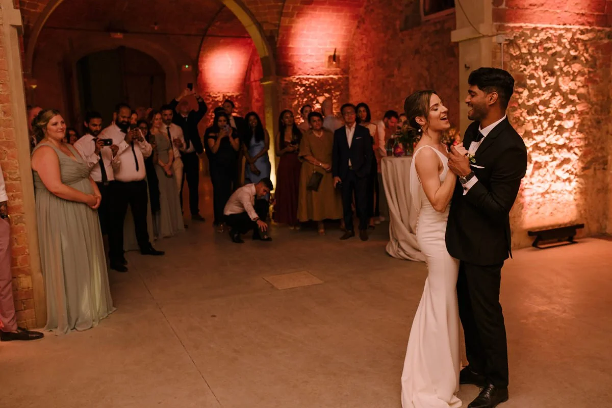 Bride and groom dancing their first dance inside the large party room at Tenuta di Monaciano.