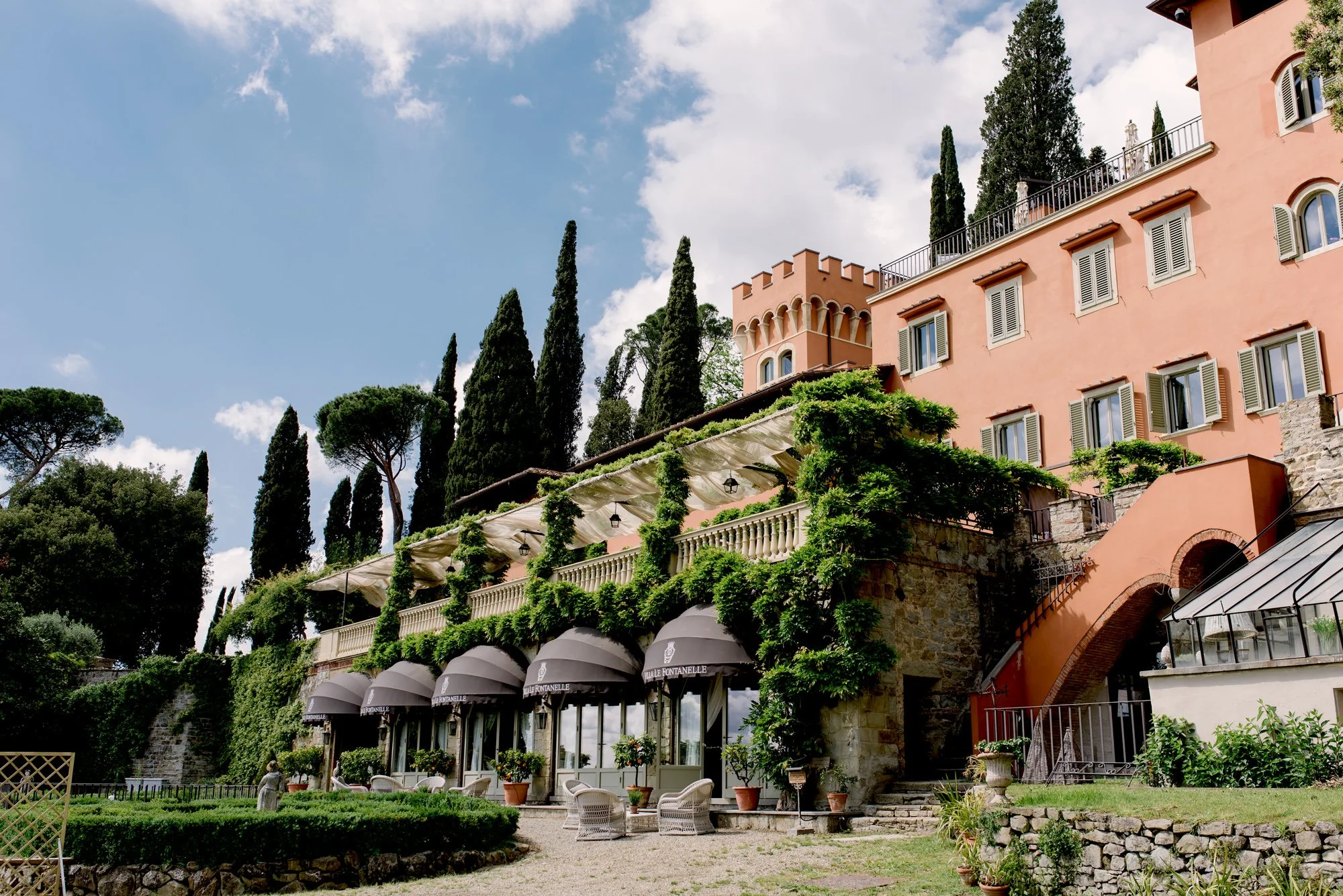 View of a Tuscany wedding venue villa near Florence with gardens and hillside scenery.