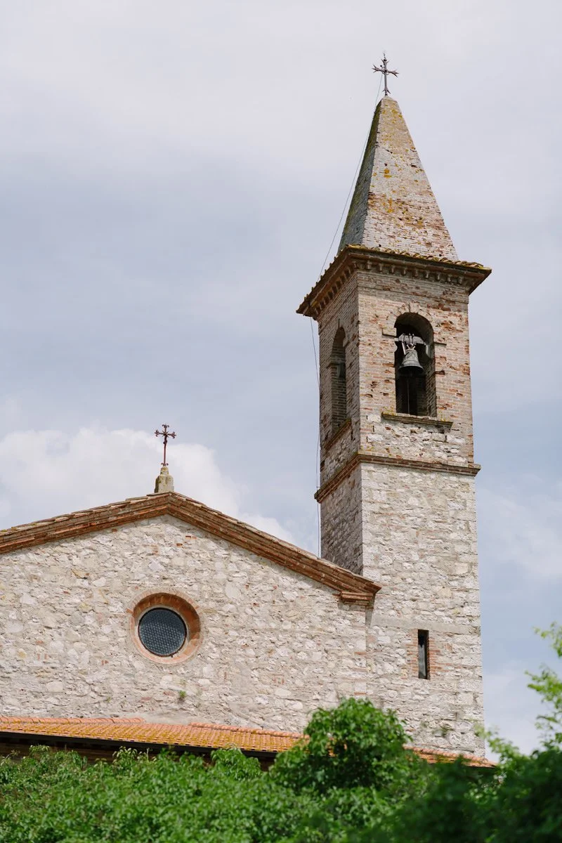 View of the historic church tower roof at Borgo Pietrafitta overlooking the Tuscan hills.