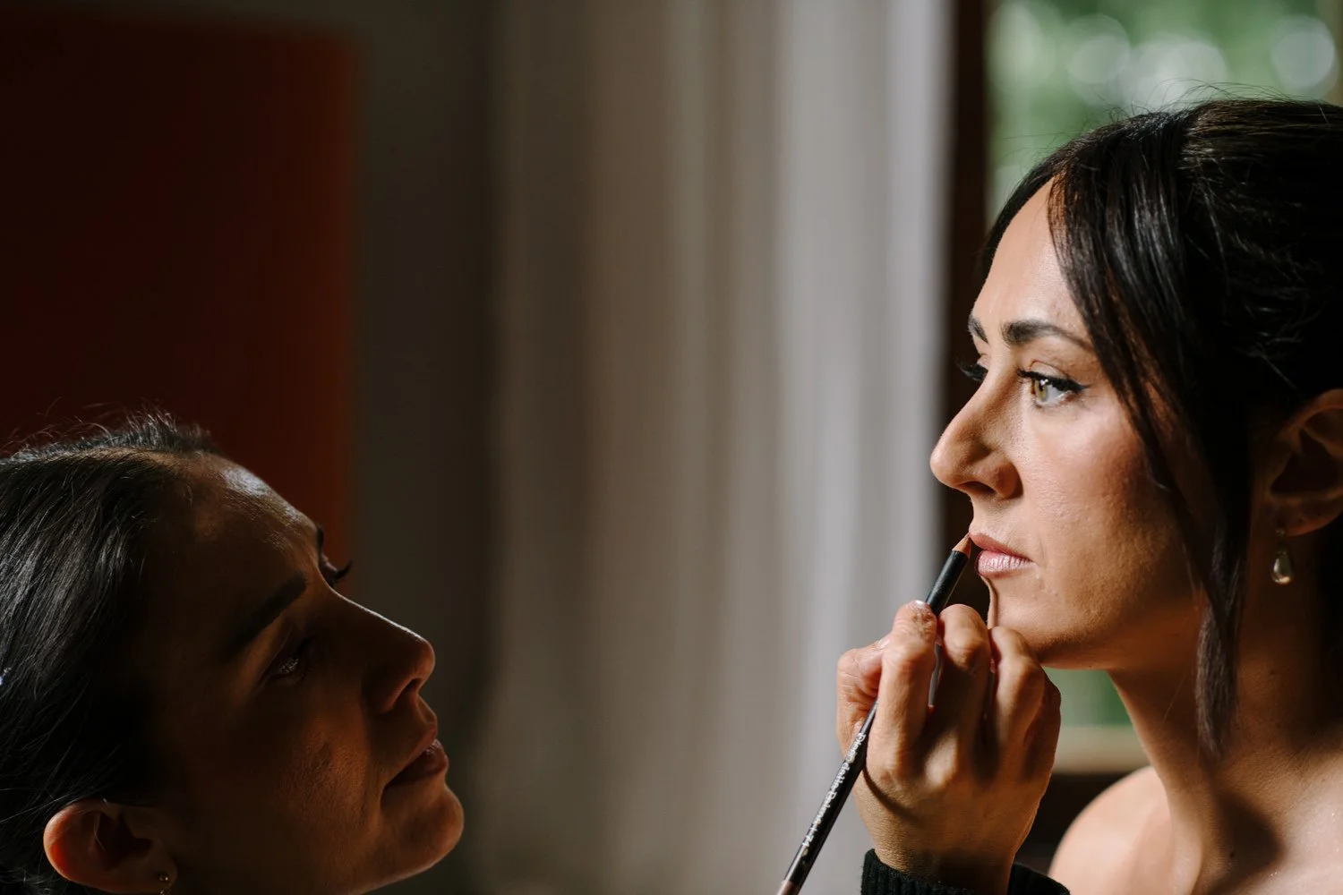 Bride during hair and makeup before her October wedding at Villa di Ulignano, photographed by FunkyBird
