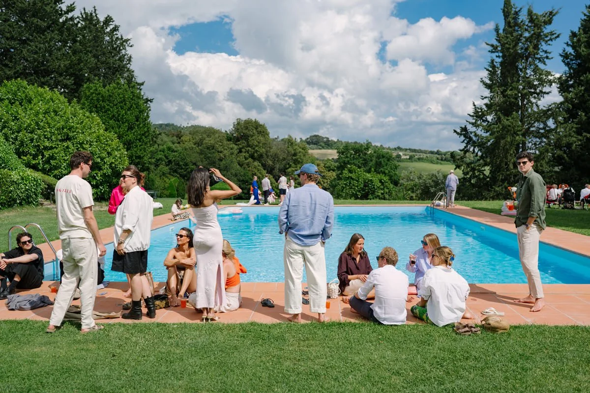 Guests relaxing by the pool at Villa di Ulignano during a day after wedding brunch in the Tuscan countryside.