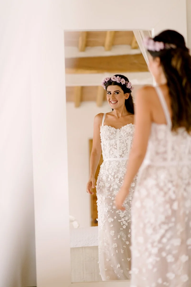 Bride smiling while looking in the mirror during wedding preparations at Conti di San Bonifacio.