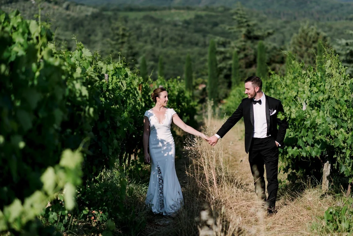 Couple holding hands and looking at each other in the vineyard at Castello di Spaltenna wedding venue.