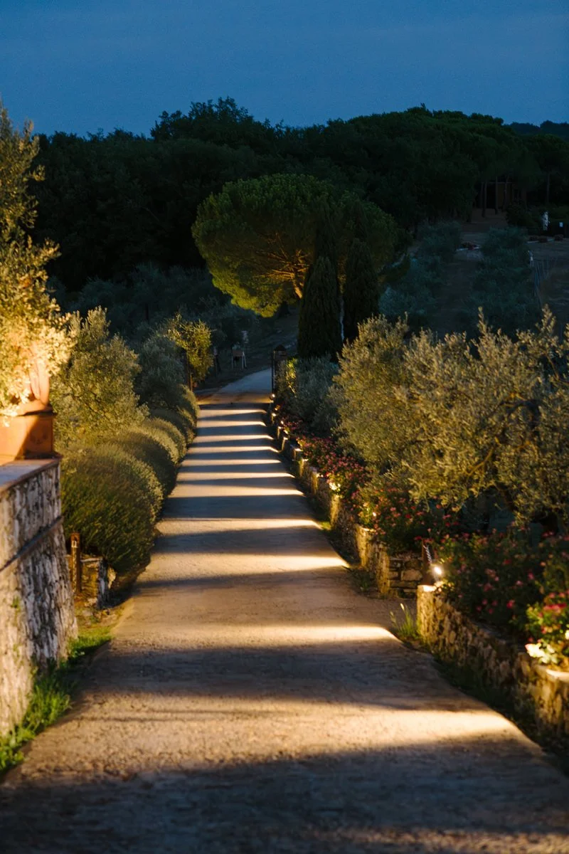 Long entrance road at Le Filigare wedding venue photographed at night with lights along the sides.
