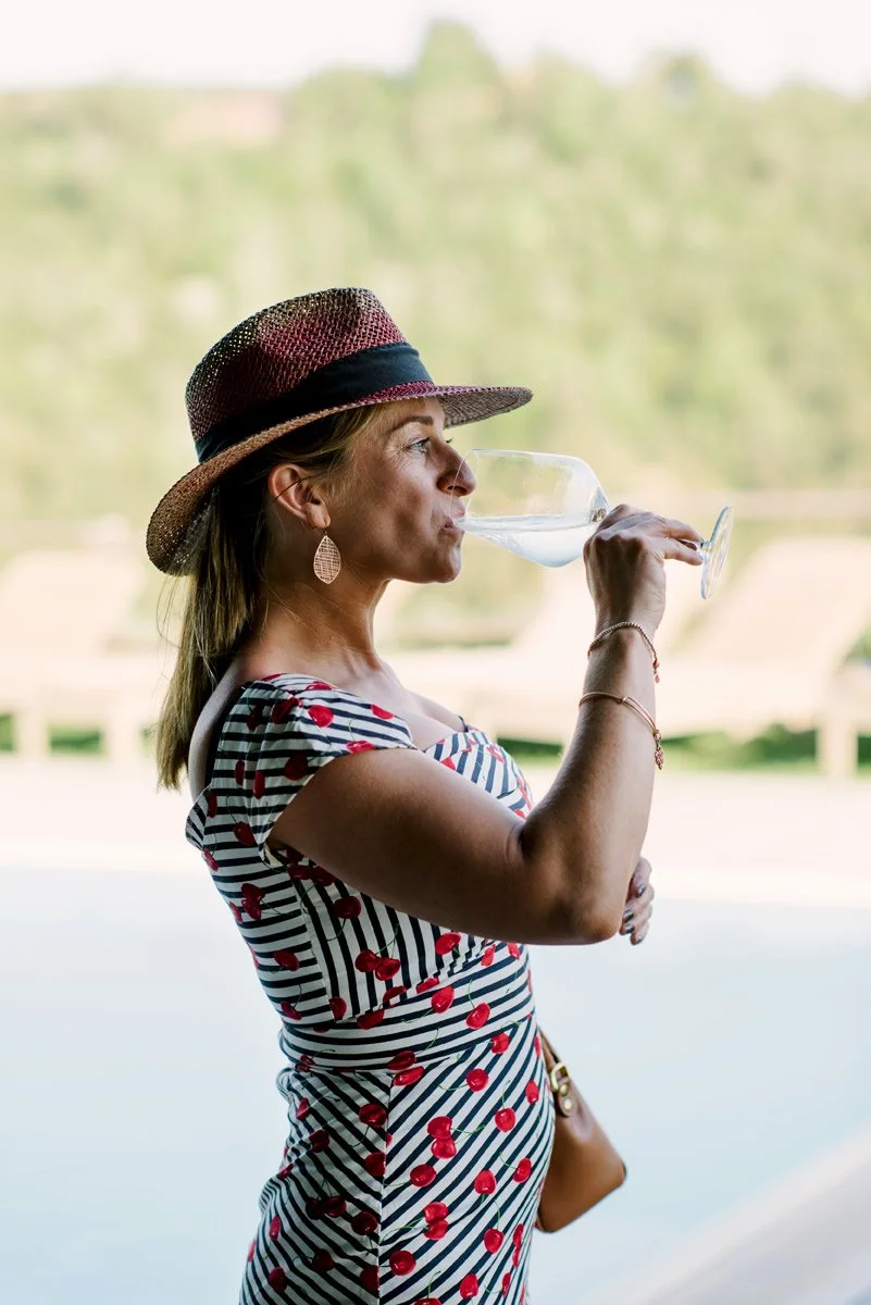 Wedding guest drinking prosecco during aperitivo at Conti di San Bonifacio in Tuscany.