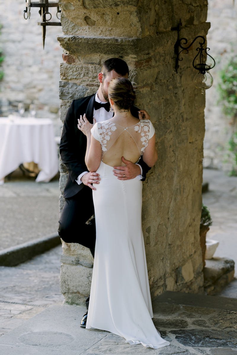Couple standing very close together in the historic courtyard of Castello di Spaltenna.
